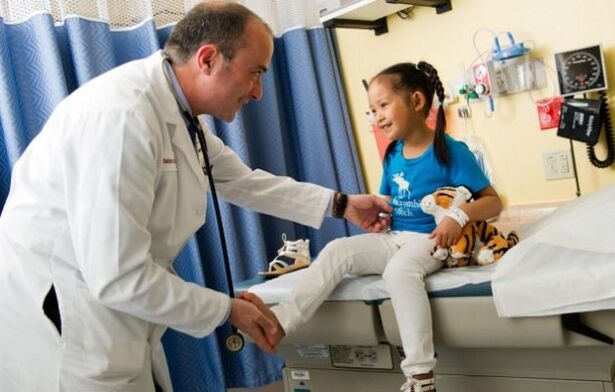 a doctor examines a child with hip arthrosis